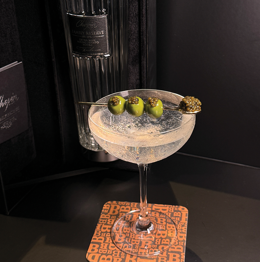 Martini cocktail with three olives and caviar garnish
