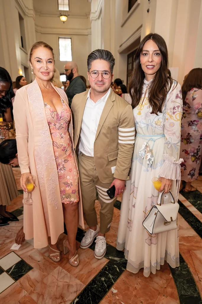 A man in center, with two women smiling.