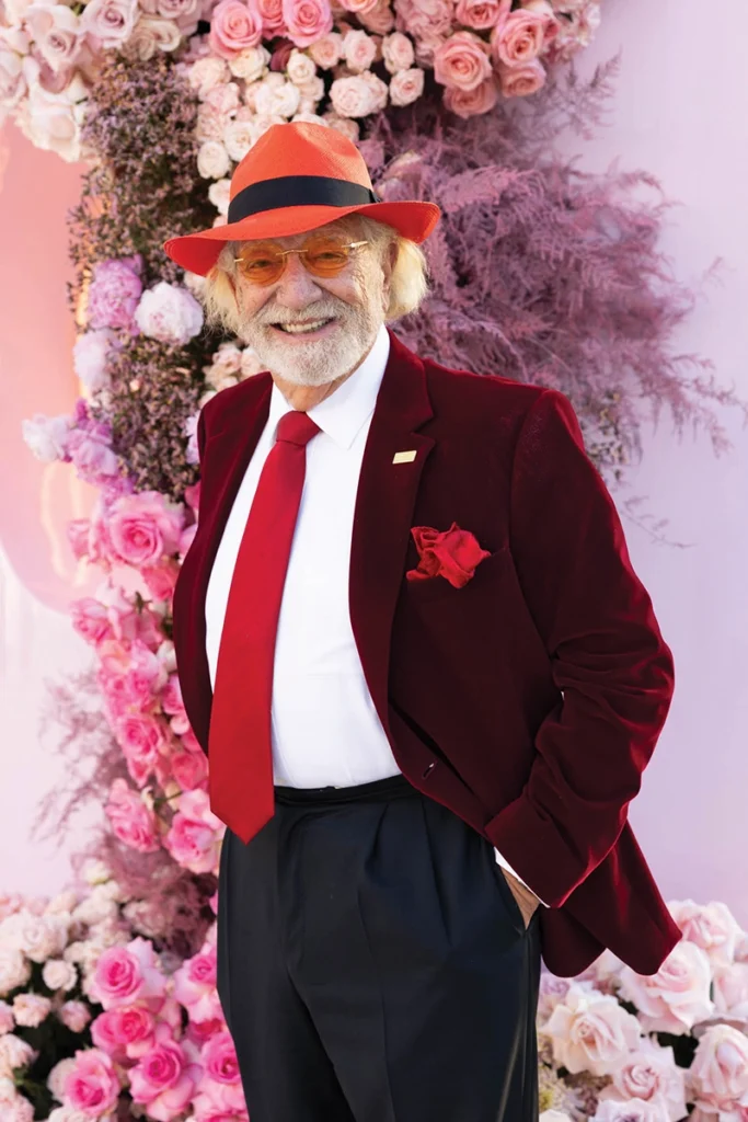 A man smiling, wearing hat and sunglasses.