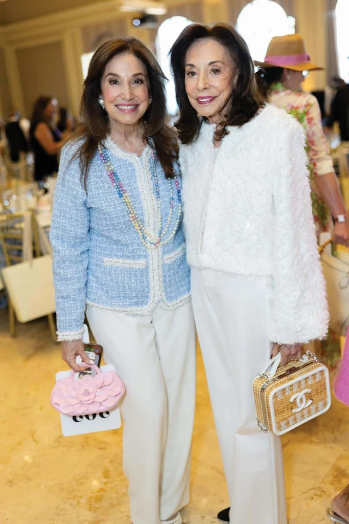 Two women smiling, holding vintage handbags.