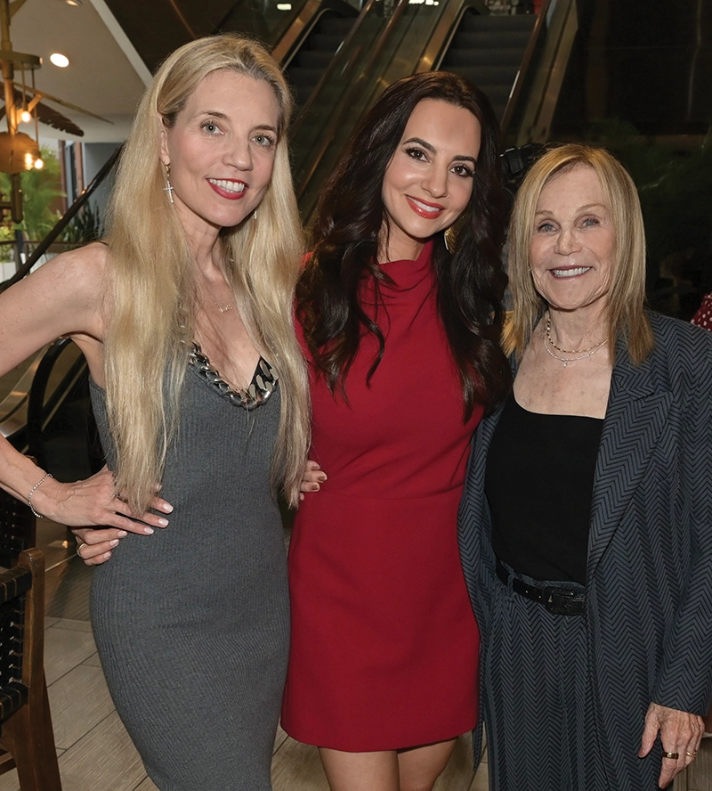 three woman smiling in front of escalator