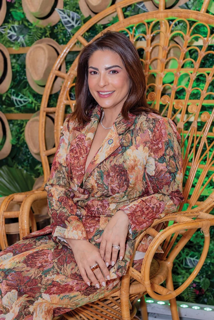 woman in floral dress siting in an oversized wicker chair