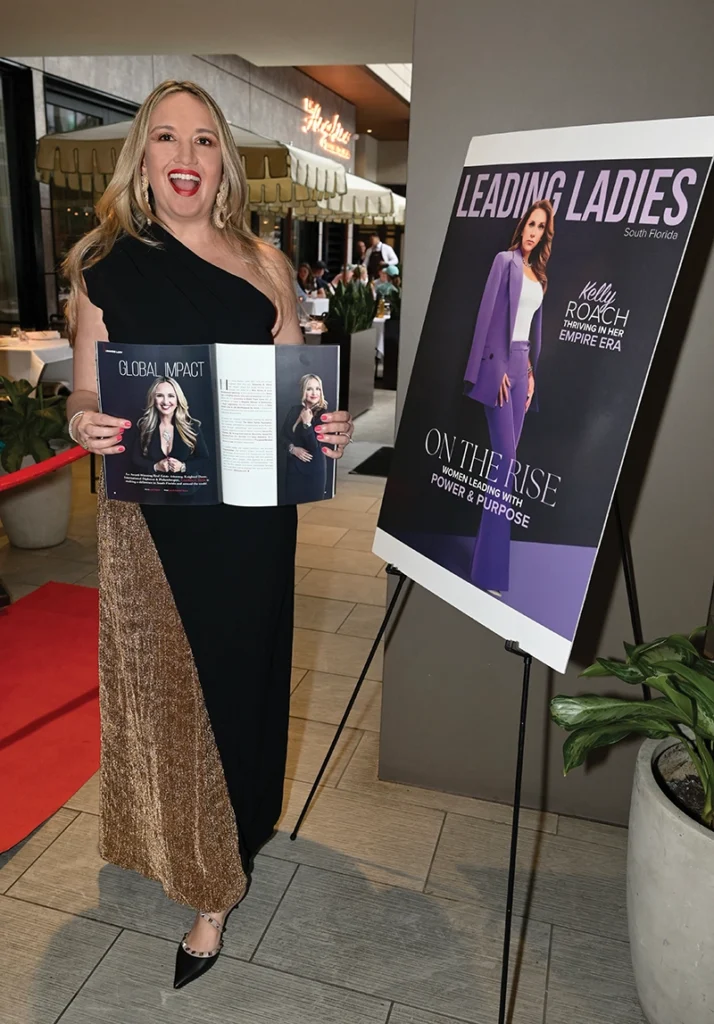 woman smiling and holding up magazine feature next to magazine cover
