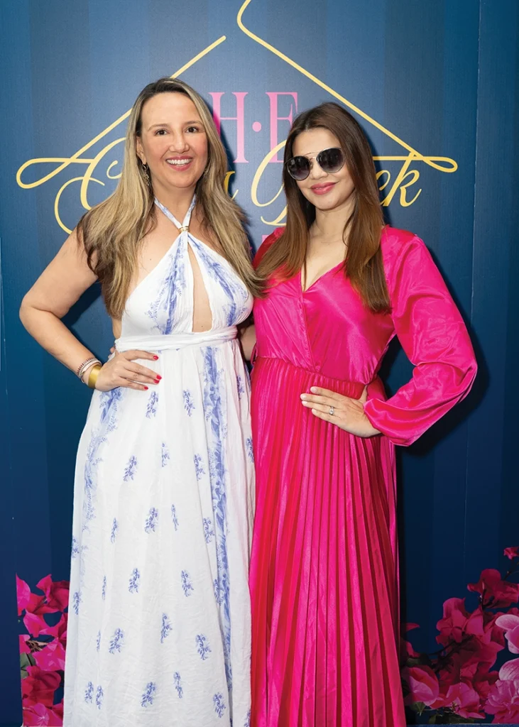 Two women smiling, the one on the right wearing sunglasses.