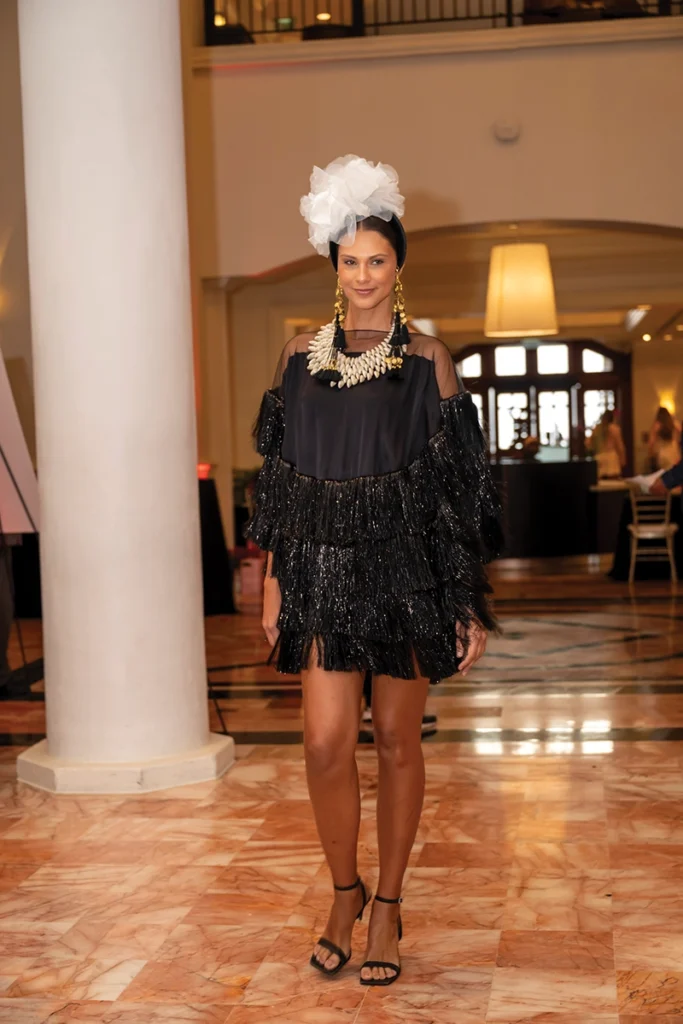 Model in designer clothes in a hotel lobby.