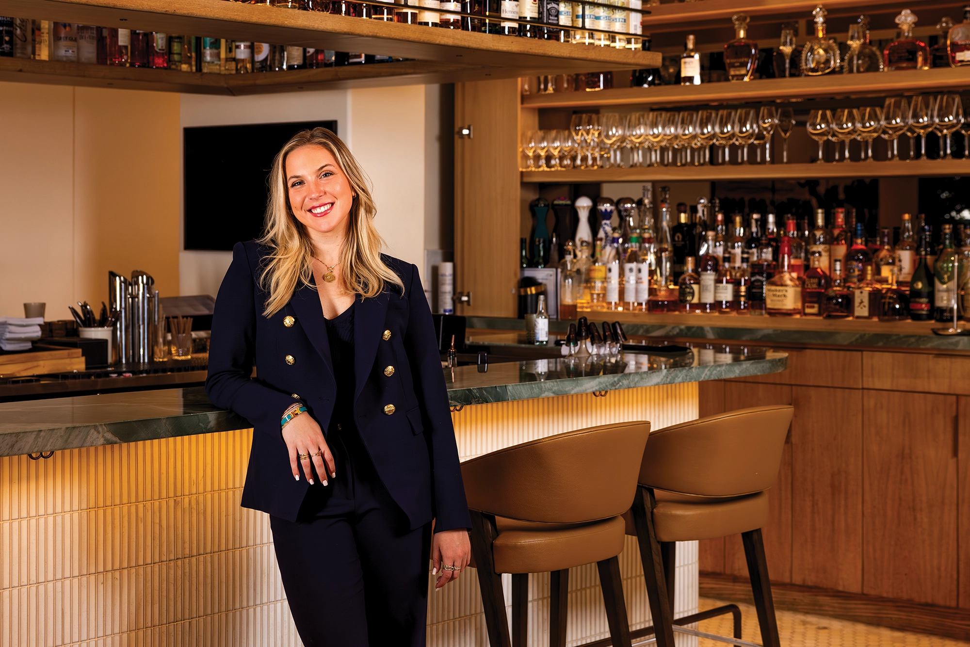 Woman smiling in front of bar at a restaurant.