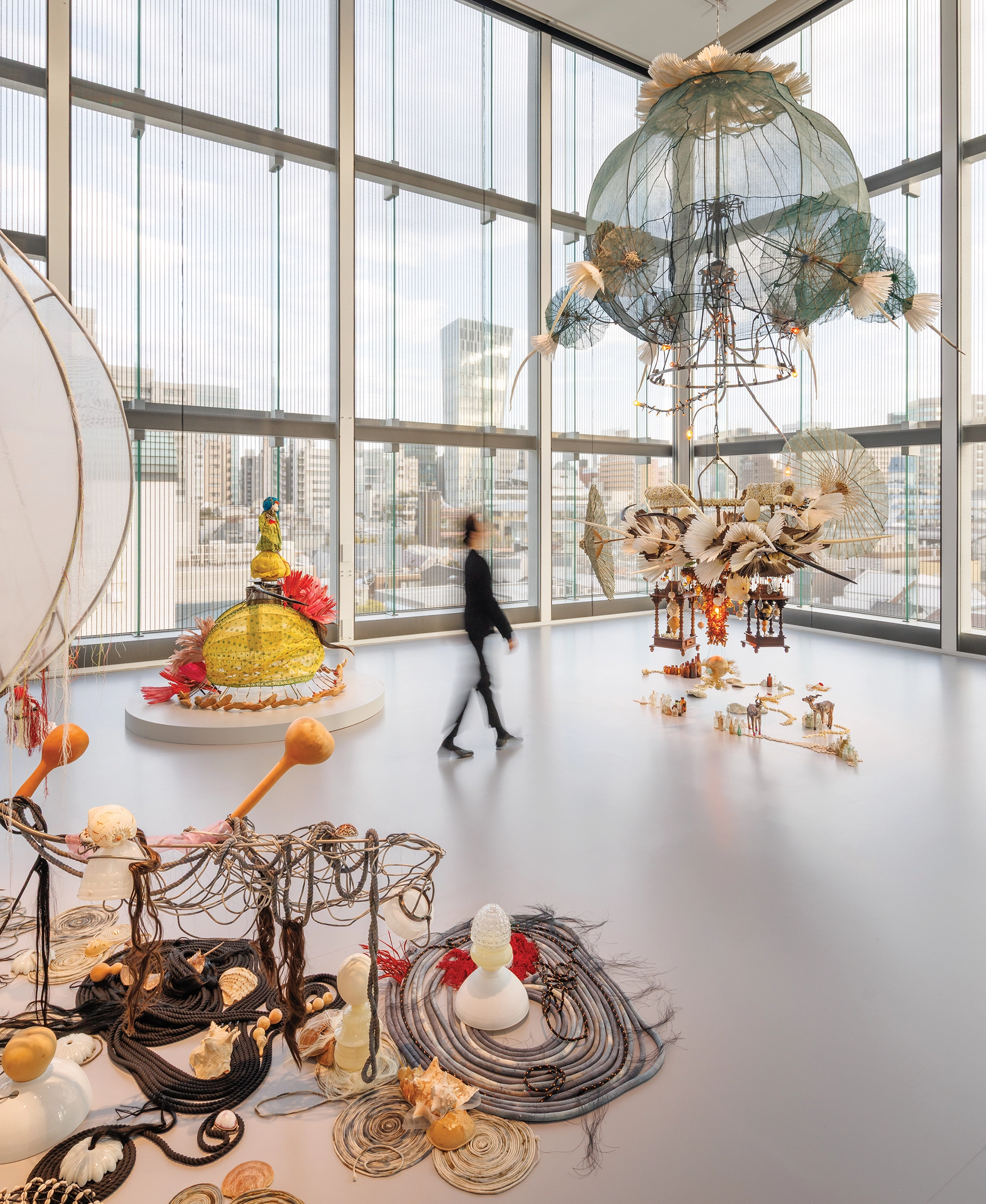 Woman walking in an apartment with art installations on ceiling and floor.